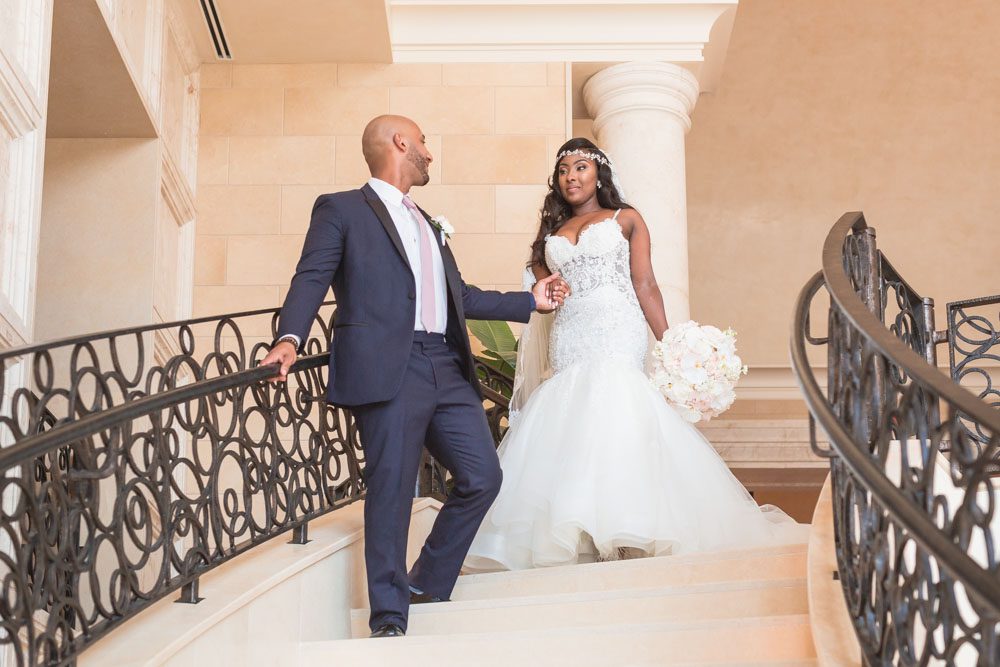 Newlyweds walking down the steps at their Four Seasons wedding in Orlando captured by top photography and videography team