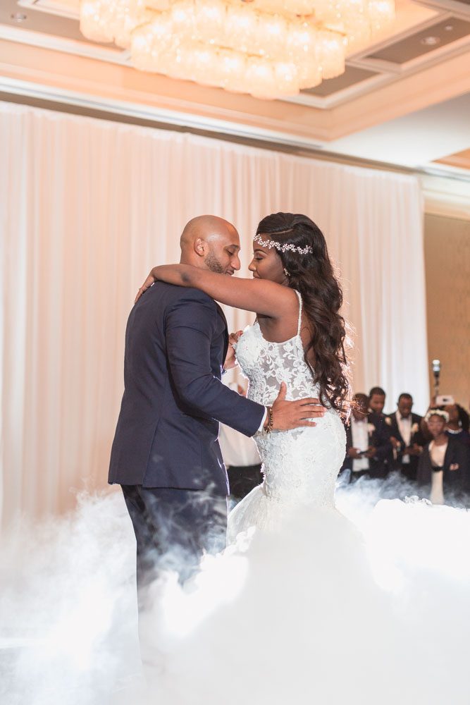 Bride and groom share their first dance on a cloud captured by top Orlando wedding photographer at their Four Seasons reception