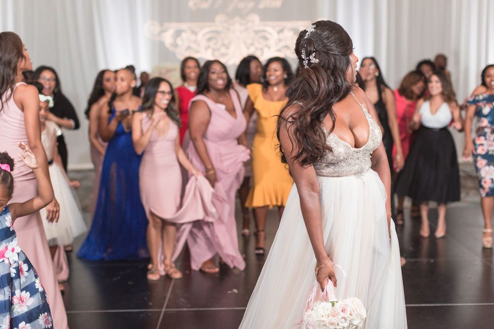 Orlando wedding photographer captures the bride as she throws her bouquet during her wedding reception at the Four Seasons