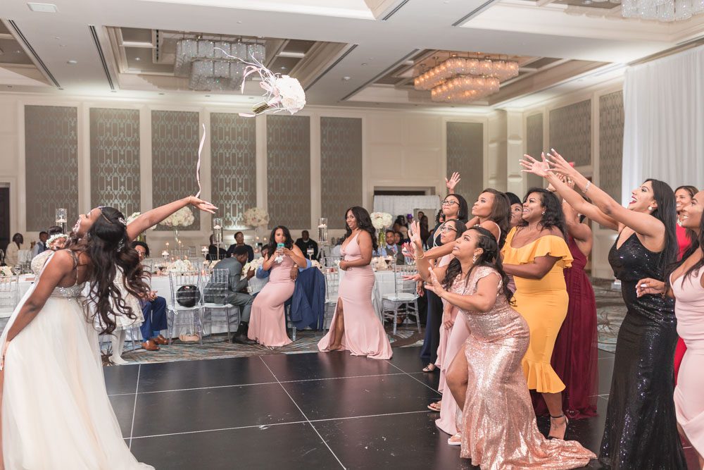 Orlando wedding photographer captures the bride as she throws her bouquet during her wedding reception at the Four Seasons
