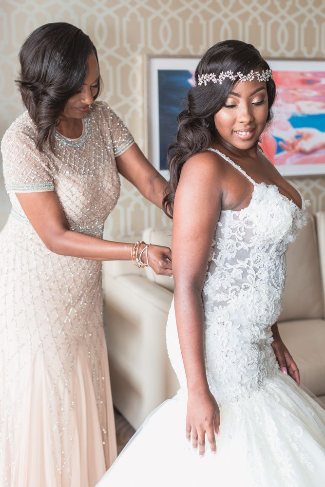 Bride getting into her wedding dress with her mom at the Four Seasons in Central Florida