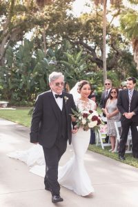 Bride walking down the aisle at outdoor wedding ceremony in Port Orange venue captured by top Orlando wedding photographer
