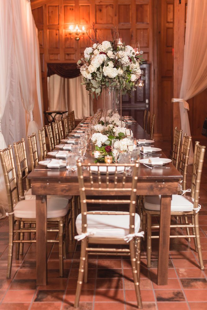 Elegant reception decor featuring a white and burgundy red color palette at the Estate on the Halifax near Orlando
