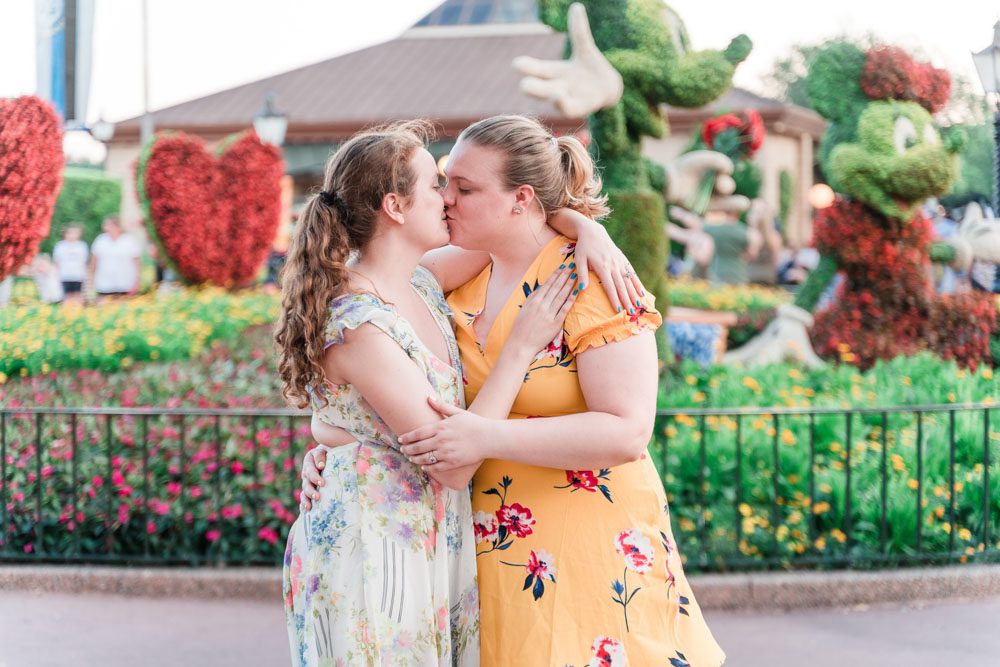 Brides kiss in Epcot during their same sex engagement photography session with top Orlando gay wedding photographer