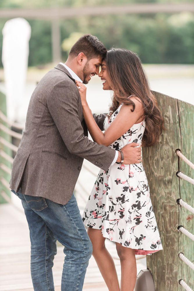 Candid and romantic engagement photo on the dock at the Grand Floridian captured by top Orlando engagement photography team