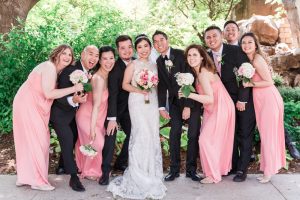Fun candid photo of the wedding party wearing pink bridesmaid dresses captured by top Orlando wedding photographers
