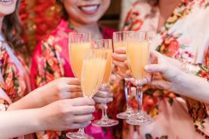 Bride and bridesmaids share a toast during wedding day preparation