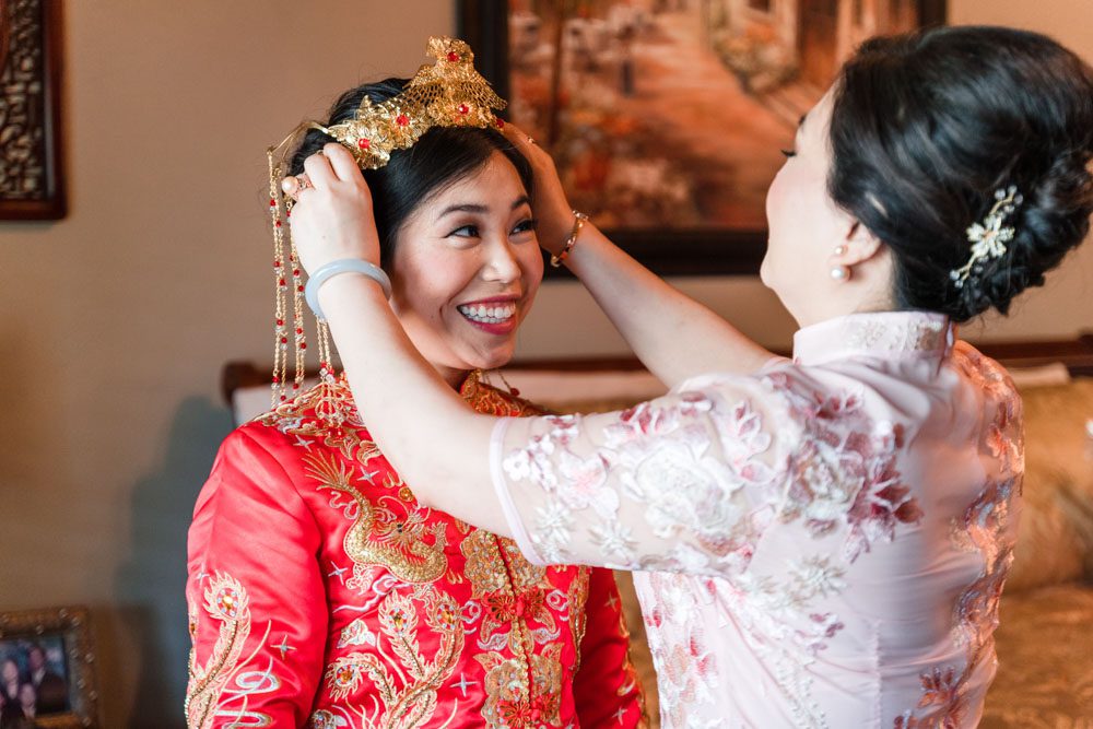 Brides mom helps her with traditional chinese headpiece during her Asian wedding in Oklahoma City
