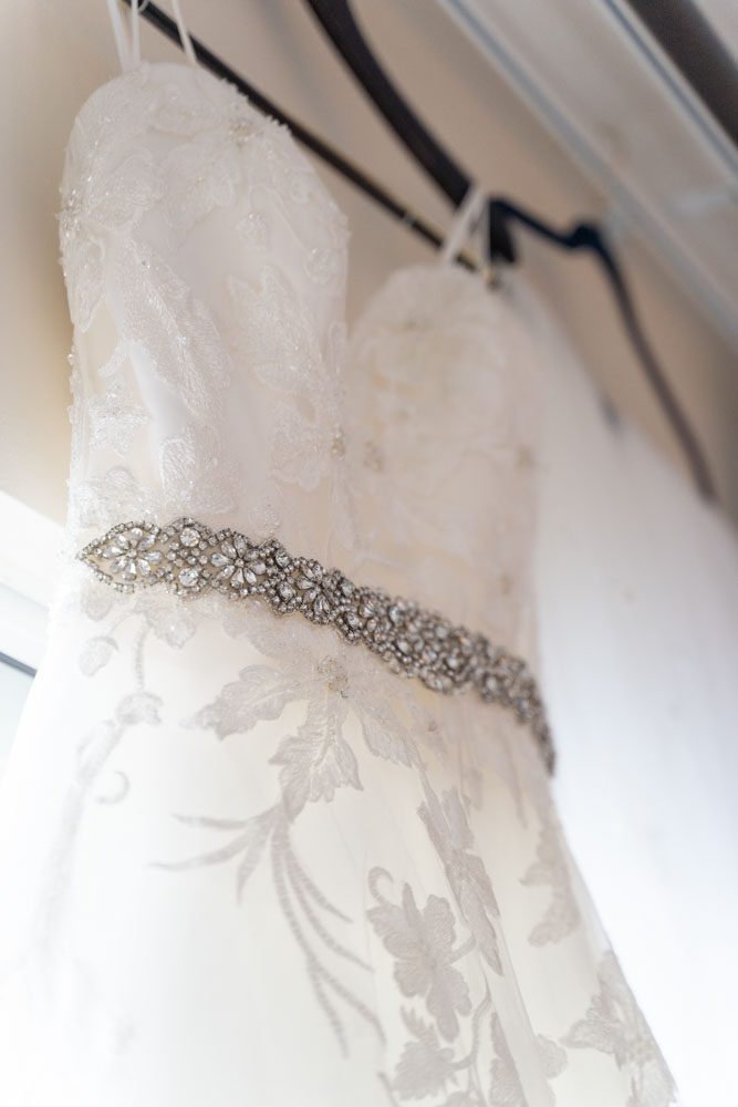 Brides dress hanging in the window during wedding day preparation for her Orlando wedding