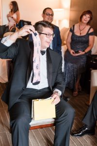 Groom opens a fun gift from the bride of socks with her face during their Orlando wedding day
