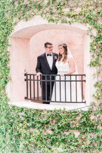 Beautiful and romantic portrait of bride and groom standing at a balcony during their wedding in Orlando Florida