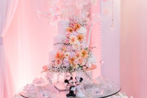 Beautiful white wedding cake covered in fresh flowers during Orlando wedding at the Crystal Ballroom