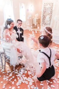 Flower girl and ring bearer throw rose petals at the bride and groom at the Crystal Ballroom wedding venue in Orlando