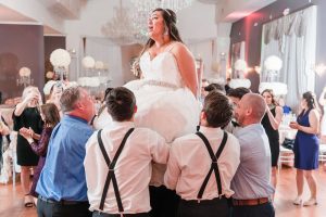 Bride being lifted for the Jewish tradition the hora during their Orlando wedding reception at the Crystal Ballroom