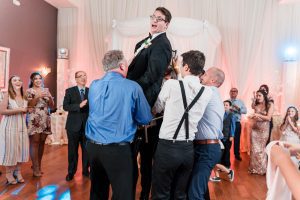 Groom being lifted for the Jewish tradition the hora during their Orlando wedding reception at the Crystal Ballroom
