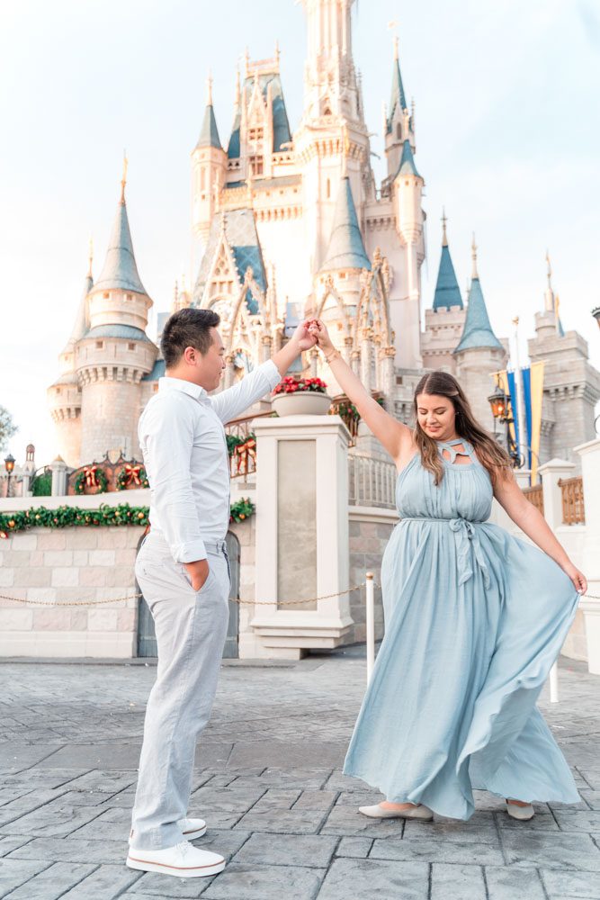 Romantic engagement session with a flowy dress in front of the castle at Magic Kingdom in Orlando