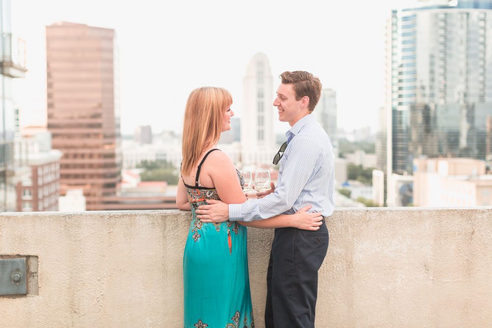 Orlando rooftop surprise proposal featuring roses, wine and the downtown skyline at sunset