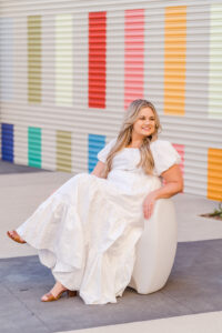 Bride poses in front of colorful wall at Orlando engagement session in Lake Nona