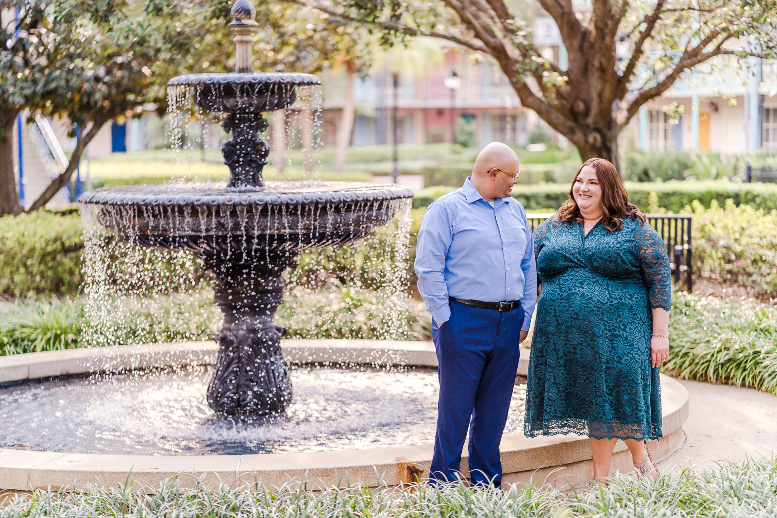 Romantic engagement photo at Disney Port Orleans resort with plus size bride in front of a fountain