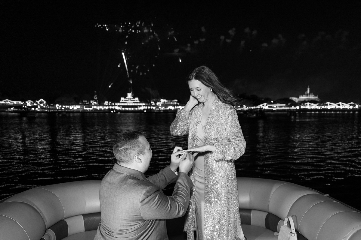 Black and white emotional moment at a surprise proposal with fireworks at Disney World in Orlando, Florida