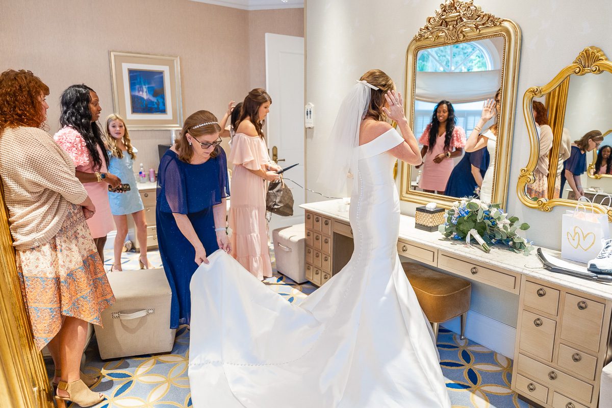Bride getting ready in vestibule at Disney's Wedding Pavilion venue captured by the best Orlando wedding photographer and videographer