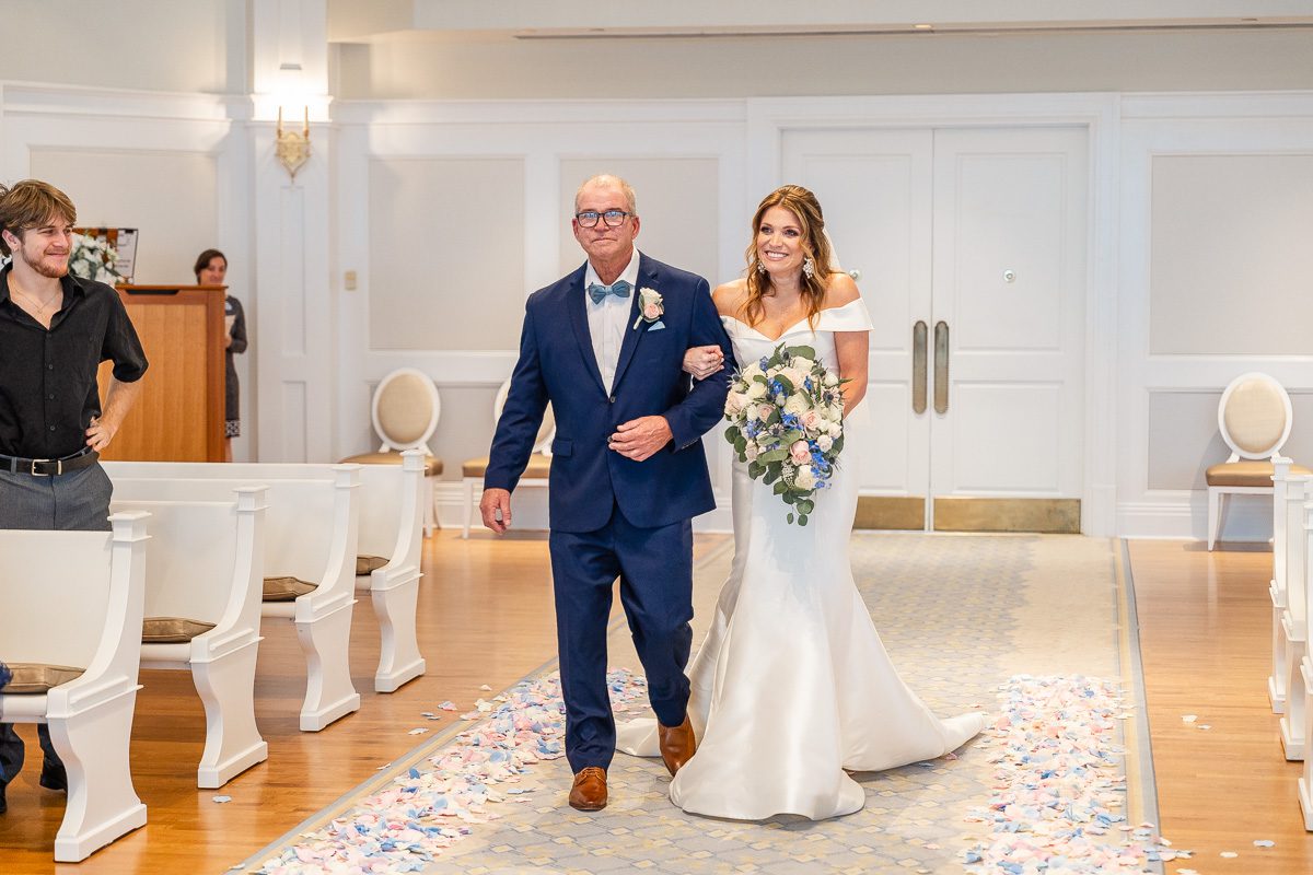 Bride entering Disney's Wedding Pavilion captured by top Orlando photographer and videographer at Christmas