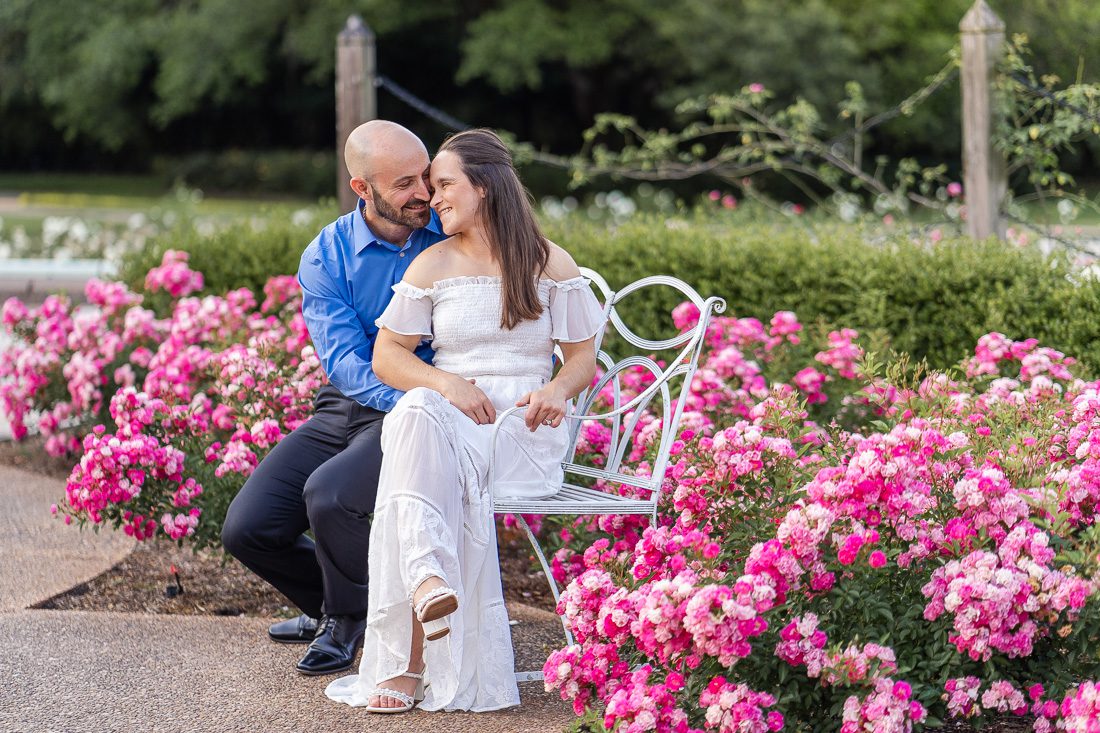 Dreamy engagement session on a bench in a rose garden with top ranking Orlando photographer