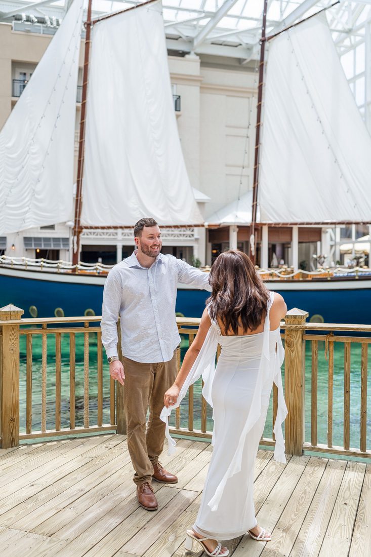 Fun dancing photo in front of a sailboat at Gaylord Palms Kissimmee indoor atrium with top rated photographer