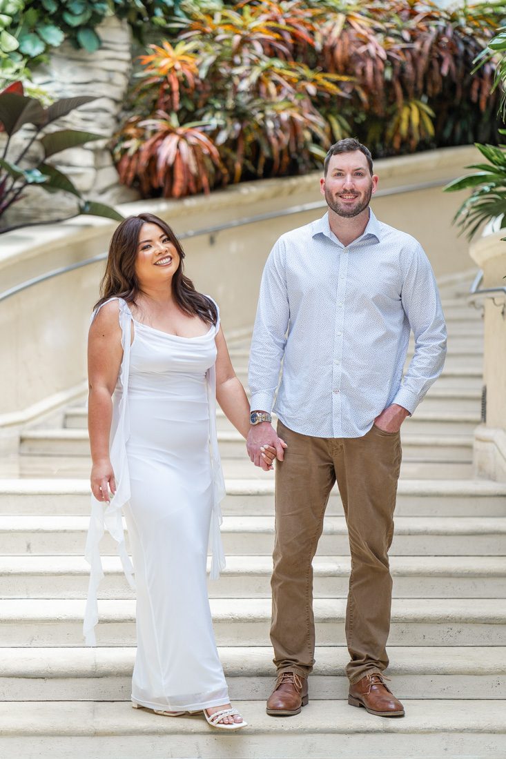 Elegant engagement photo on a grand staircase indoors at the Gaylord Palms resort in Kissimmee by top Orlando photographer