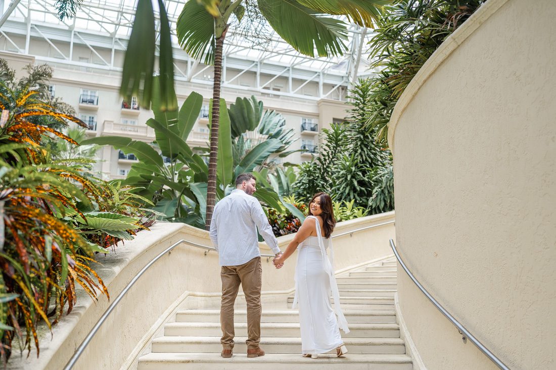 Elegant engagement photo on a grand staircase indoors at the Gaylord Palms resort in Kissimmee by top Orlando photographer