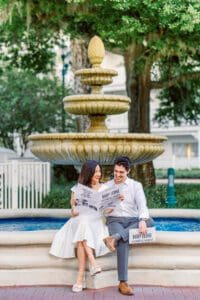 Pregnancy announcement with a newspaper at the Grand Floridian fountain with top Disney photographer