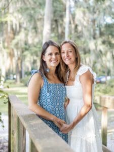 Couple smiling and holding hands on a wooden bridge surrounded in Kraft Azalea Park, Top Orlando Wedding Photographer