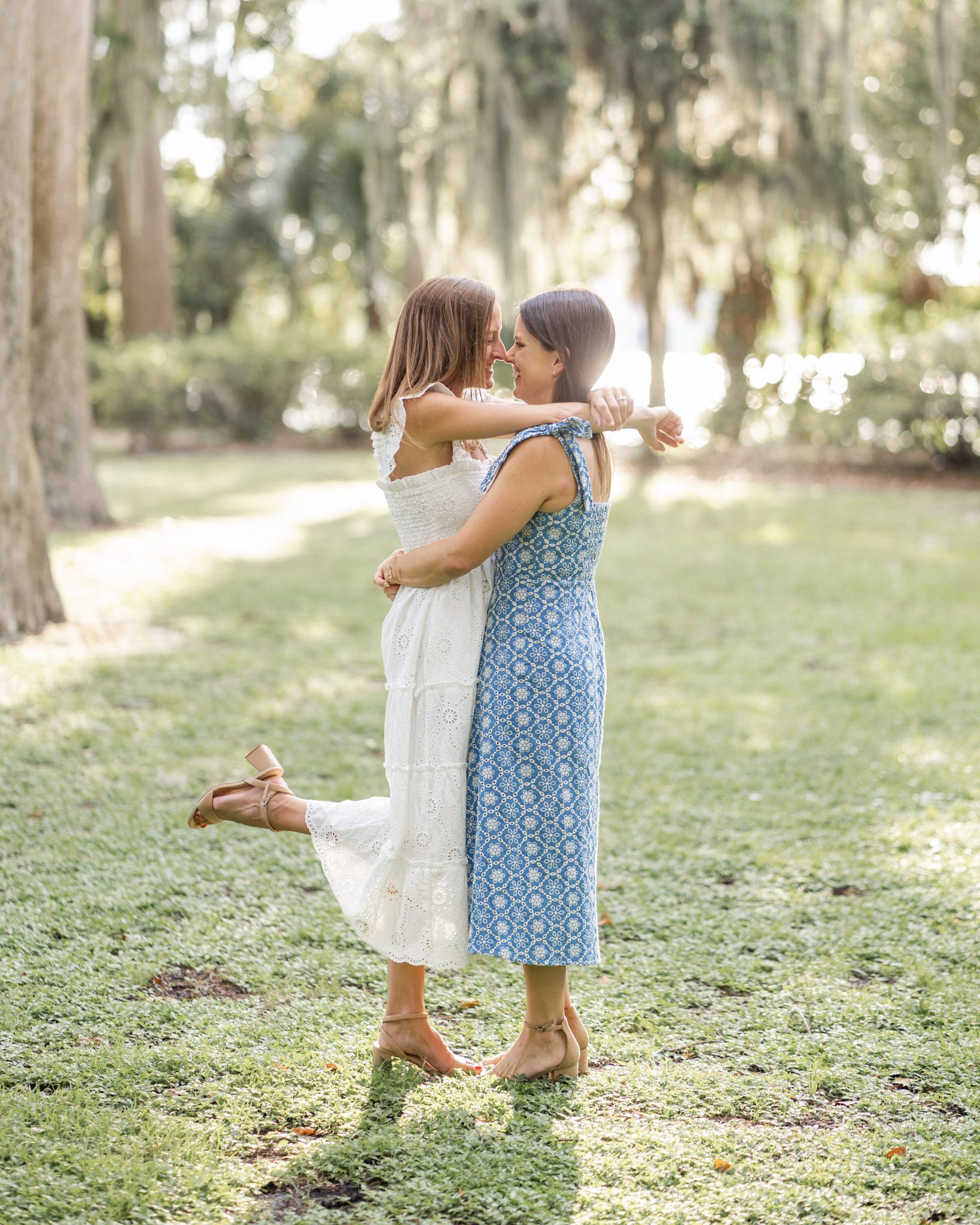 Close up portrait of a joyful LGBTQ couple in light summer dresses, holding hands during their engagement session by top Orlando Wedding Photographer