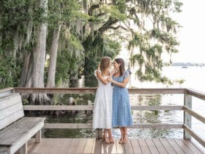 Close up portrait of a joyful LGBTQ couple in light summer dresses, holding hands during their engagement session by top Orlando Wedding Photographer