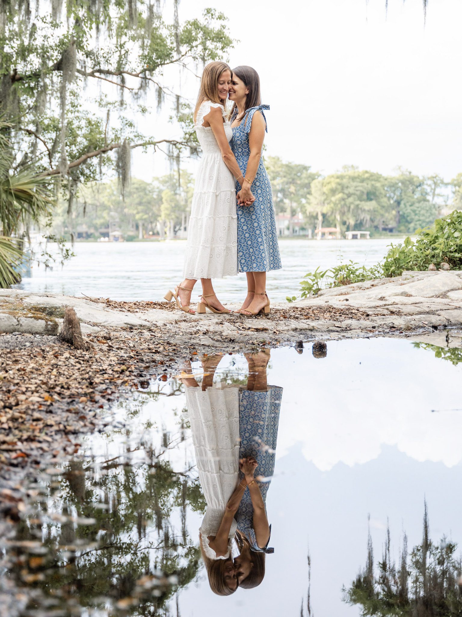 Romantic engagement photo of a same-sex couple silhouetted by the evening sun at Kraft Azalea Park by top Orlando wedding photographer