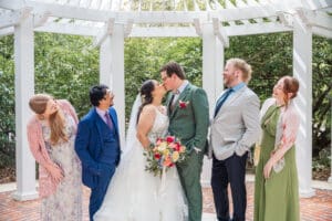 Bride and groom posing with their closest family during an intimate micro wedding.