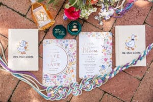 Wedding detail photo featuring handfasting cord, matching rings, vow books, and heirloom pearls.