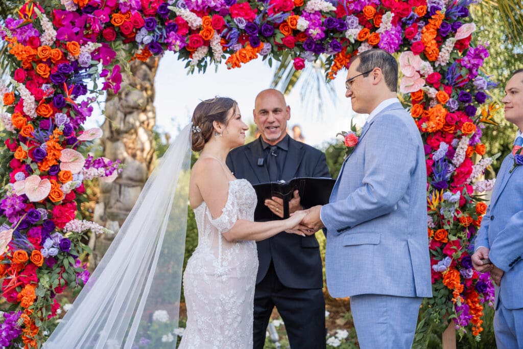 Heartfelt wedding vows surrounded by colorful florals at Evermore Resort in Orlando, beautifully documented by Captured by Elle