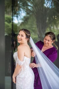 Emotional bridal getting ready moment with mother fastening the wedding dress at Evermore Resort, captured by Orlando wedding photographer Captured by Elle