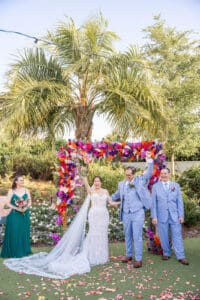 A joyful post-ceremony celebration surrounded by colorful florals at Evermore Resort in Orlando, photographed by Captured by Elle, luxury wedding photographer